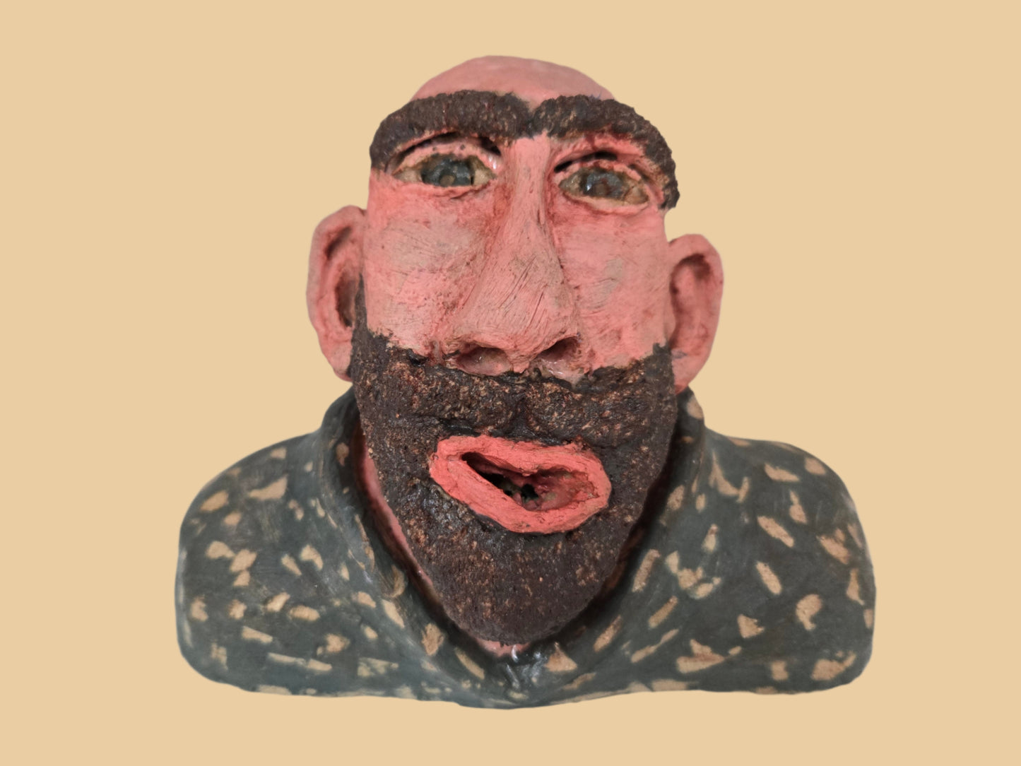 Bust of a man with a textured face and beard.