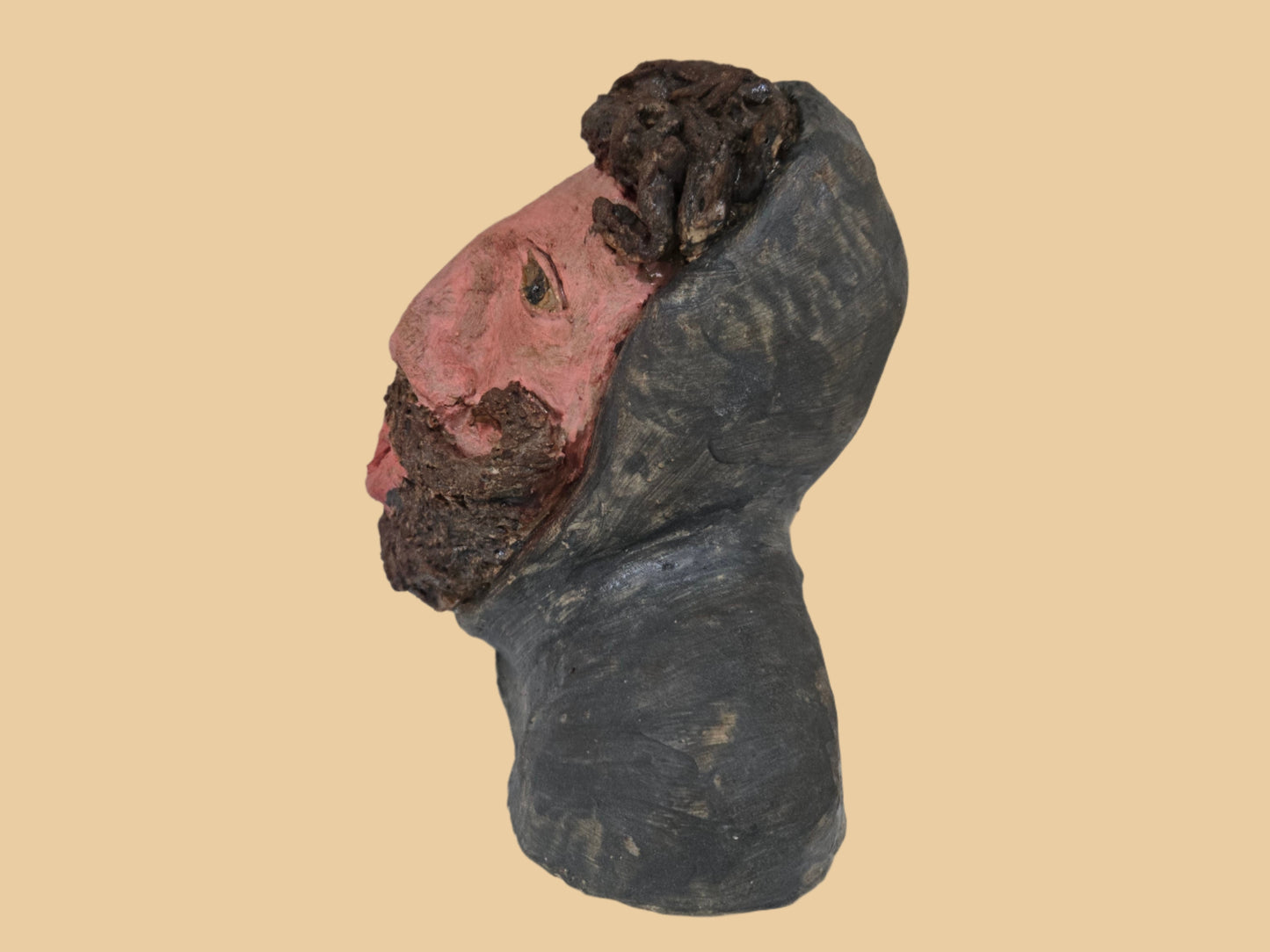 Ceramic head sculpture on a white surface with a plain background