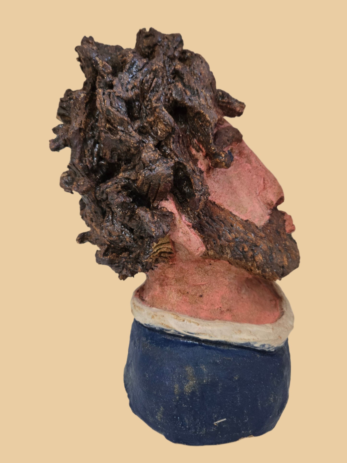 Close-up of a damaged ceramic head with a textured surface on a plain background