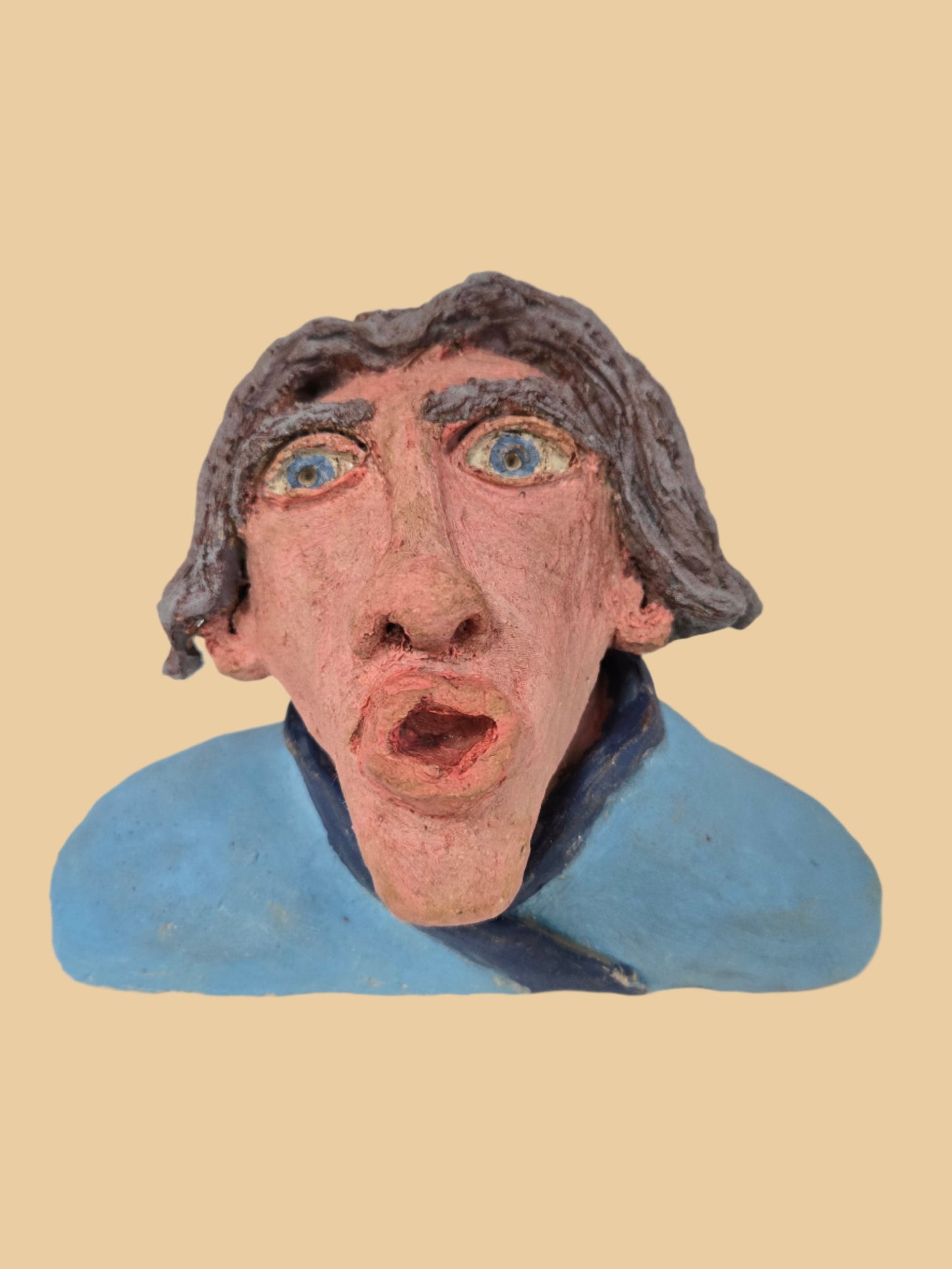 Small sculpture of a face with grey hair on a white background